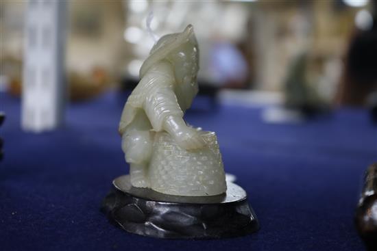 Two Chinese celadon jade figures of a fisherman and a lion-dog, 6.2 and 11cm, wood stands